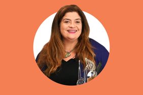Alex Guarnaschelli smiling visible torso on an orange background