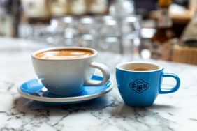 Two coffee cups one larger and one smaller on a marble table