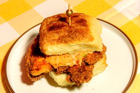 Millers All Day Dog Walker breakfast sandwich featuring a biscuit fried chicken and sauce with a toothpick securing it