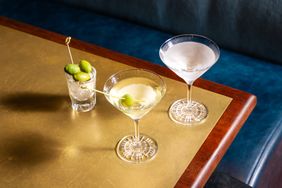 Two martini glasses from Hawksmoor with garnishes on a table featuring cocktails