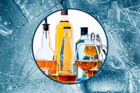 Various liquor bottles and glasses surrounded by ice