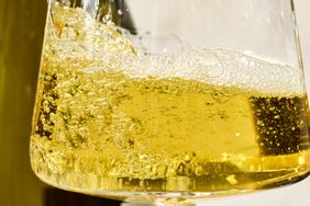 A closeup of a glass of white wine with visible bubbles