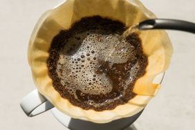 Pouring water over coffee grounds in a filter for brewing