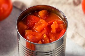 An open can of diced tomatoes on a kitchen counter