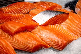 Several fillets of salmon displayed on ice
