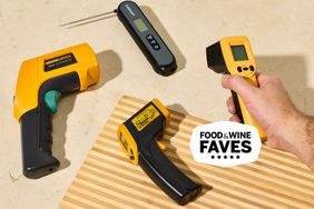 person holding infrared thermometer with other thermometers around