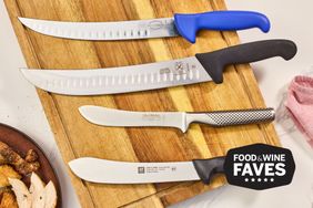 Four butcher knives on a wooden cutting board