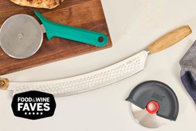 three pizza cutters on a surface with a cutting board and pizza crust