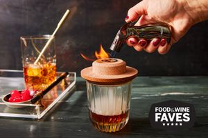Person testing an Old Fashioned cocktail with the Aged & Charred Cocktail Smoker
