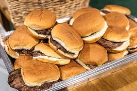 A tray filled with hamburger buns and beef patties