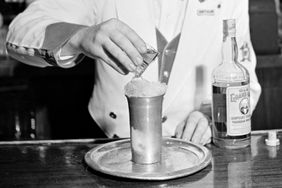 A bartender makes a cocktail with Old Grand-Dad Kentucky bourbon whiskey at the New Yorker Hotel in New York City, USA, 20th April 1942. 