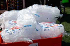 Bags of ice in a red cooler outdoors