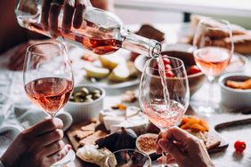 A group of people enjoy rose at a restaurant