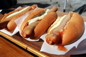 Icelandicstyle hot dogs served in buns with condiments on a wooden surface