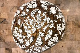 Loaf of rye bread with a crackled crust on a wooden surface