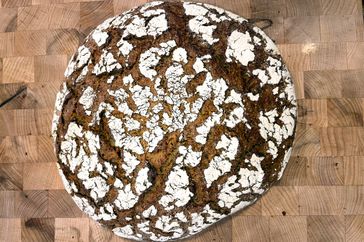 Loaf of rye bread with a crackled crust on a wooden surface