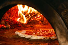 Pizza being cooked in a woodfired oven