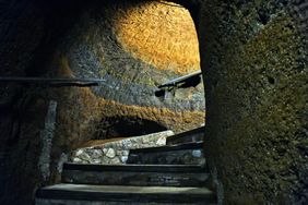 Steps leading through an ancient cave with stone walls and rustic ambiance