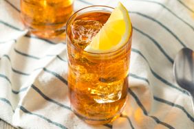A glass of iced tea with a lemon wedge garnish