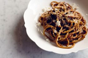 A dish of Lapaba's Bucatini & Amatriciana served with sauce and garnished with grated cheese on a white plate