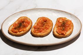 Three slices of bread topped with a tomato mixture on an oval plate
