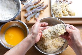 Horse mackerel and shrimp being prepared with egg wash, flour and panko breadcrumbs.