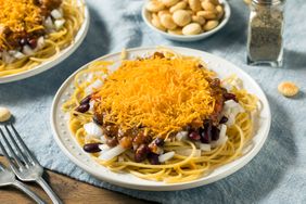 Homemade Cincinnati chili spaghetti with cheddar cheese and chopped onion