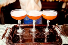 Three cocktails served in coupe glasses on a silver tray