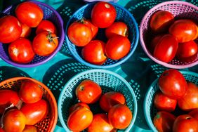 Baskets containing tomatoes placed on a surface