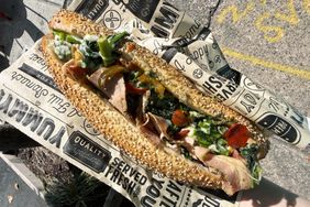 Philadelphiastyle roast pork sandwich on a sesame roll with greens and toppings