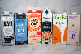 Six brands of oat milk in cartons displayed side by side on a countertop