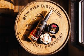 A bottle of New Riff Distilling bourbon with ice cream on a wooden barrel