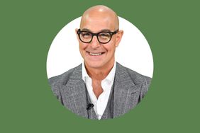Stanley Tucci smiling wearing glasses and a suit