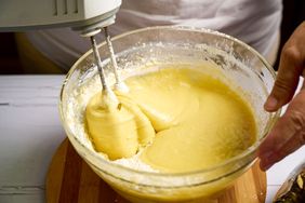 A mixing bowl with batter being stirred with an electric hand mixer