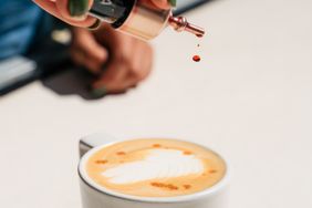 Bitters being added to a coffee drink.