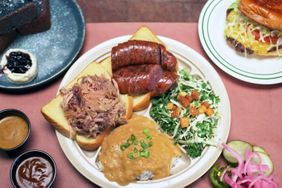 A plate of barbecue food including sausage pulled pork sides and bread at LeRoy & Lewis-Barbecue.
